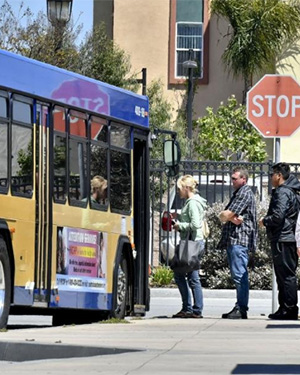 People lined up to get on a public bus