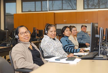 People sitting in a computer lab with headphones on
