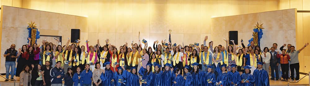 Large group of noncredit students wearing graduation robes